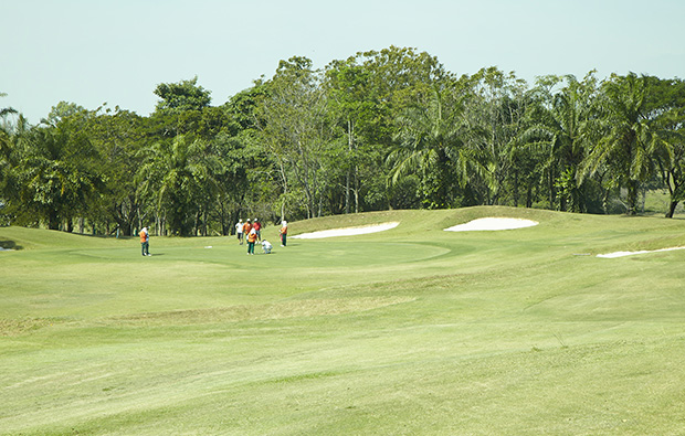 caddies on green at pattaya country club, pattaya